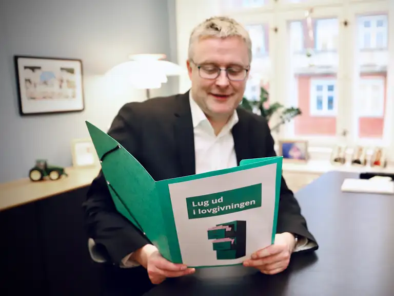 Fødevareminister Jakob Jensen læser rapport om projektet Lug Ud i Lovgivningen